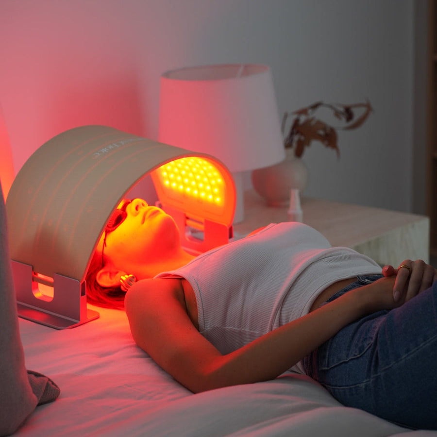 NursesChoice LED Face & Body Dome Pro arching over a woman lying back during a red light session, stocked at The Glow Co. Aesthetics Gordon Park Brisbane